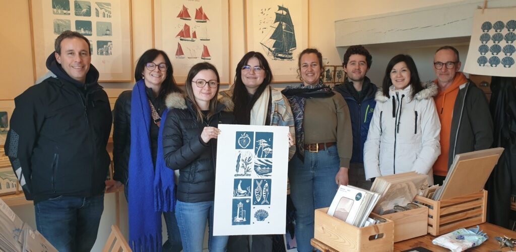 Création collective en linogravure Groupe de participants présentant une création collective réalisée lors d'un atelier de linogravure à Plougastel-Daoulas